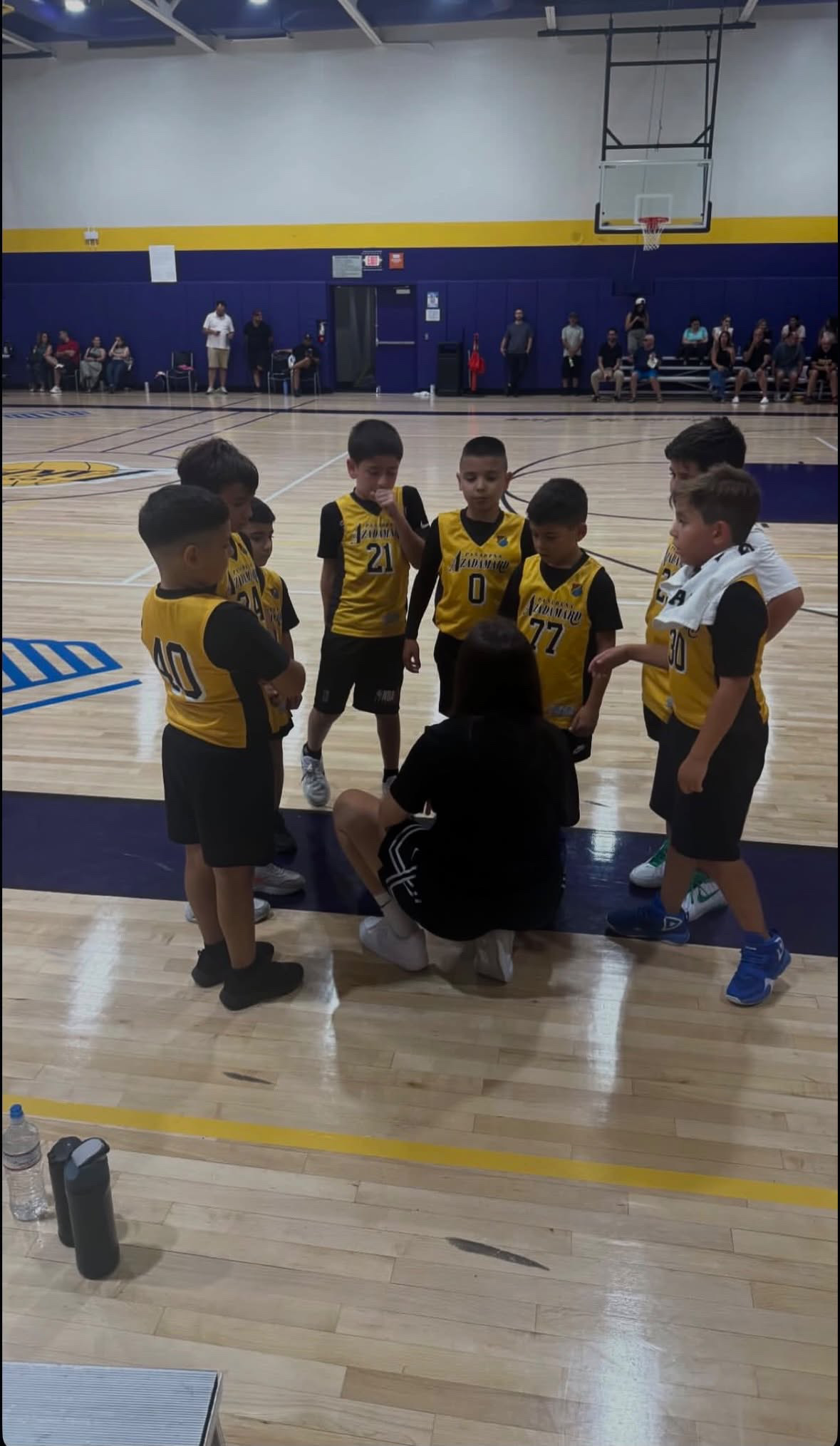 Coach Alique coaching the AZU9 youth team in a huddle